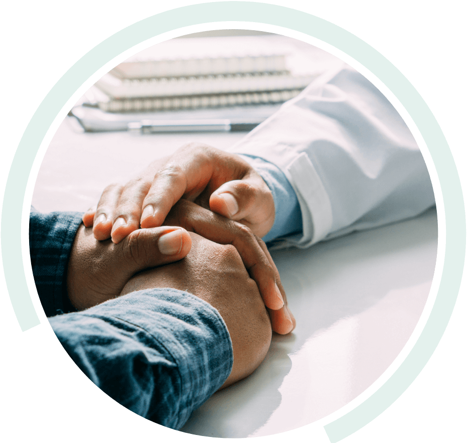 Doctor placing their hand over the folded hands of a patient